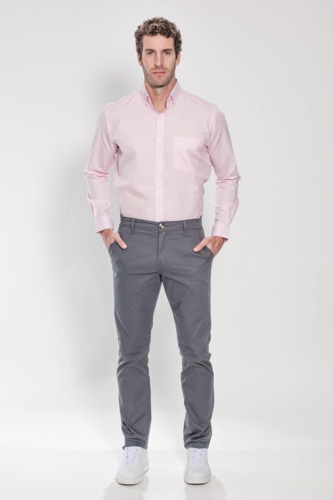 Homem com camisa rosa clara com calça social cinza.