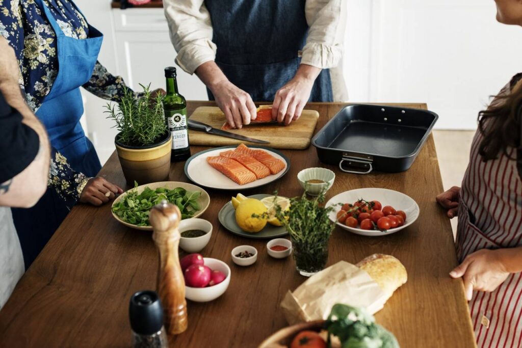 Pessoal acompanhando o professor de culinária, ensinando a fazer uma receita.