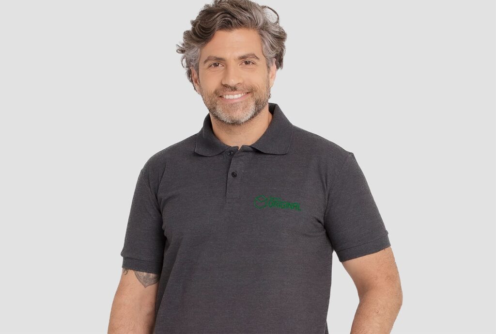 Homem vestindo camisa polo masculina na cor cinza grafite, com logotipo Banco Original aplicado no lado esquerdo do peito.