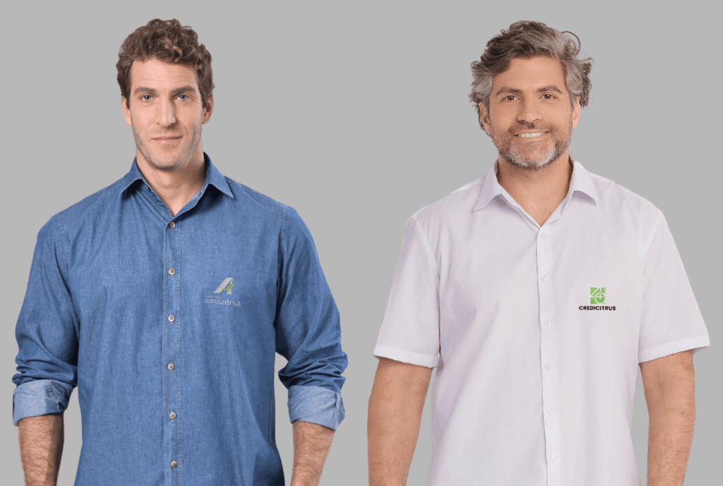 Camisas sociais masculinas personalizadas, sendo um modelo jeans do Banco da Amazônia e um modelo branco de manga curta da Credicitrus, ambas com logotipo bordado no peito.
