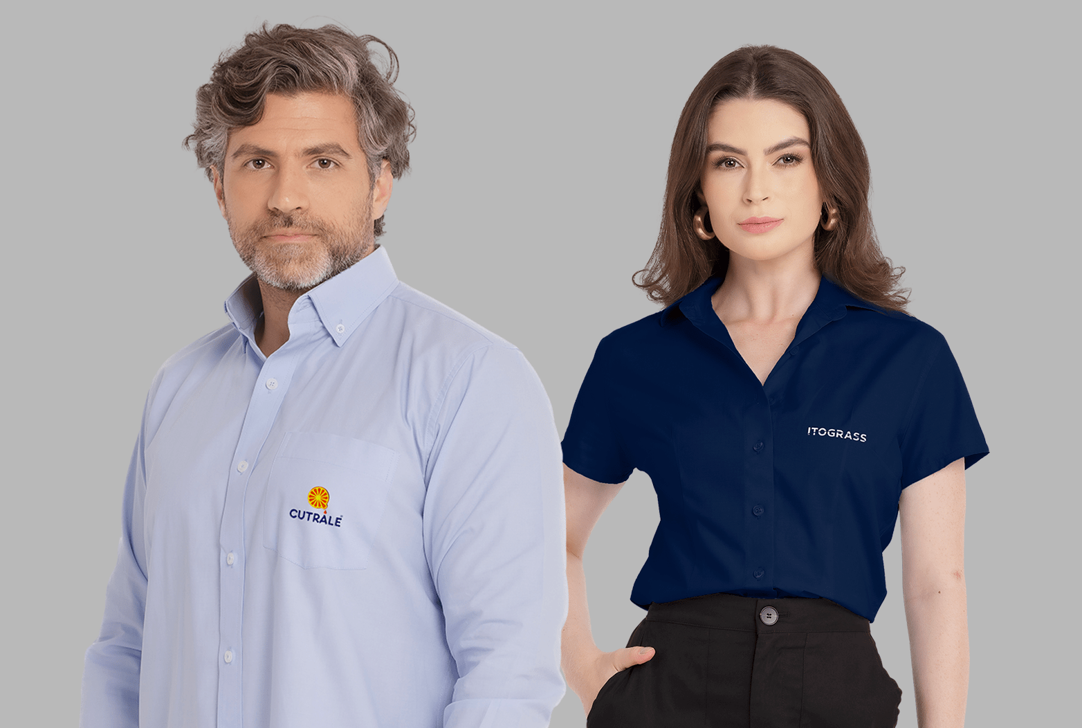 Dois modelos em fundo neutro cinza vestindo uniformes corporativos personalizados. À esquerda, modelo masculino usando camisa social azul clara de manga longa, com colarinho estruturado, bolso frontal no peito esquerdo e fechamento por botões, bordada com o logo “Cutrale” em azul acompanhado de símbolo circular em laranja e amarelo acima do nome. À direita, modelo feminina vestindo camisa social azul marinho de manga curta, com colarinho clássico e botões frontais, bordada no lado esquerdo do peito com o logo “Itograss” em branco. Ambas as peças apresentam modelagem profissional, excelente caimento e bordado empresarial de alta definição.