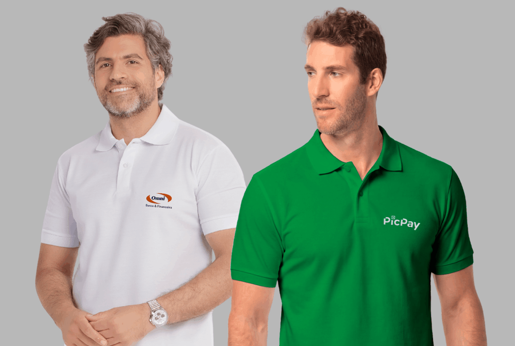 Dois modelos masculinos em fundo neutro cinza vestindo polos corporativas personalizadas. À esquerda, polo branca com gola estruturada e fechamento por botões, bordada no lado esquerdo do peito com o logo “Omni Banco & Financeira” em azul e laranja. À direita, polo verde vibrante com gola clássica e botões frontais, bordada no lado esquerdo do peito com o logo “PicPay” em branco. As peças apresentam modelagem moderna, caimento alinhado ao corpo e acabamento profissional, ideais para uniformes empresariais.