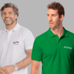 Dois modelos masculinos em fundo neutro cinza vestindo polos corporativas personalizadas. À esquerda, polo branca com gola estruturada e fechamento por botões, bordada no lado esquerdo do peito com o logo “Omni Banco & Financeira” em azul e laranja. À direita, polo verde vibrante com gola clássica e botões frontais, bordada no lado esquerdo do peito com o logo “PicPay” em branco. As peças apresentam modelagem moderna, caimento alinhado ao corpo e acabamento profissional, ideais para uniformes empresariais.