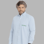Homem vestindo camisa social masculina azul clara com logotipo Viterra aplicado no lado esquerdo do peito.