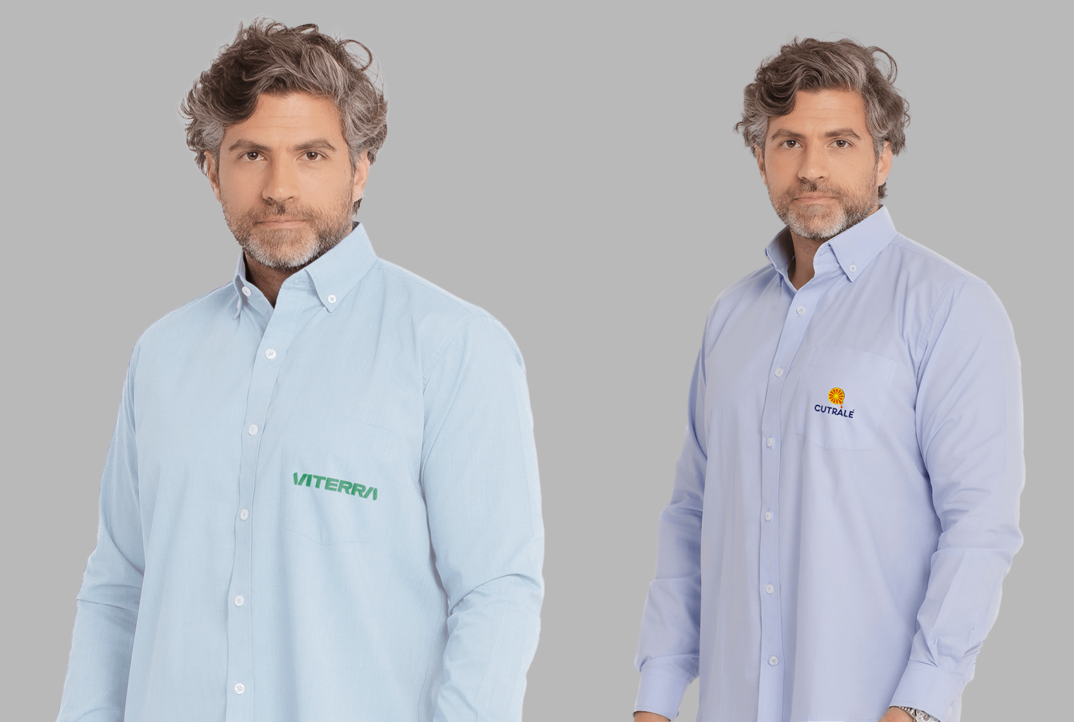 Dois modelos masculinos vestindo camisas sociais corporativas de manga longa em fundo neutro cinza. À esquerda, camisa social azul clara com fechamento por botões brancos e bolso frontal no lado esquerdo do peito, bordada com o logo “VITERRA” em verde. À direita, camisa social azul clara levemente mais intensa, também com botões frontais e bolso no peito esquerdo, bordada com o logo “CUTRALE” em azul marinho acompanhado de um símbolo circular laranja e amarelo acima do nome. As camisas apresentam modelagem tradicional, colarinho estruturado e acabamento refinado, ideais para uniformes corporativos personalizados.